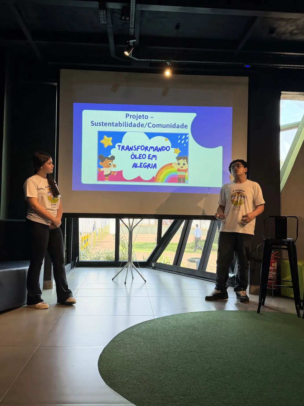 Alunos apresentando um projeto diante do telão