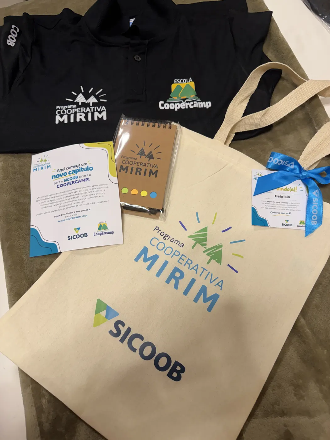 Carta de boas-vindas do Sicoob Primavera à Coopercamp, com camiseta e brindes do programa